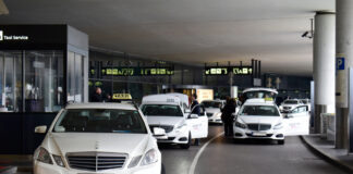 Cestujúci s kufrom nastupuje do taxi pred letiskom Schwechat.